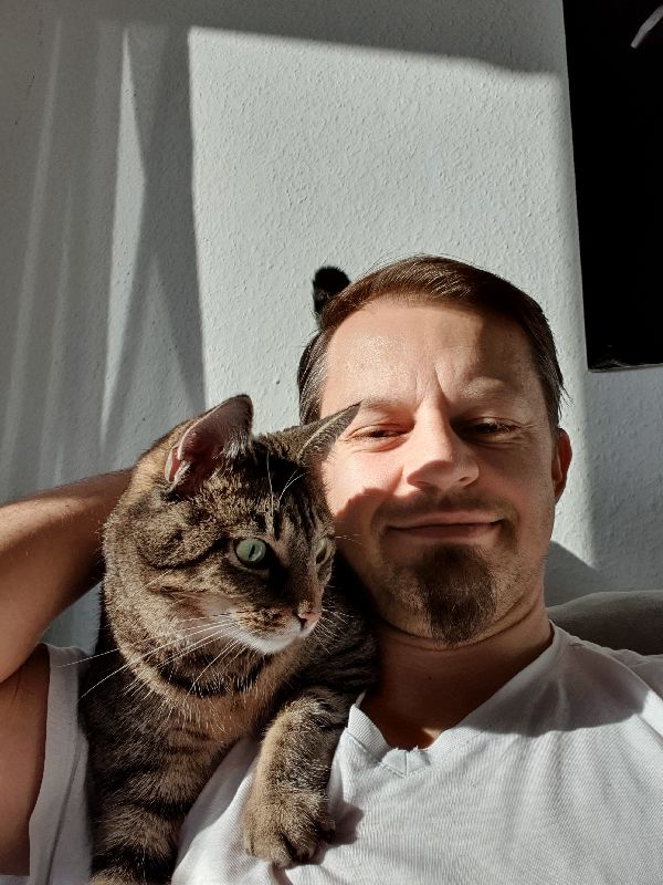 Cat Sitter Köln Katze Trixi liegt auf der Schulter von Mr Cat Cologne